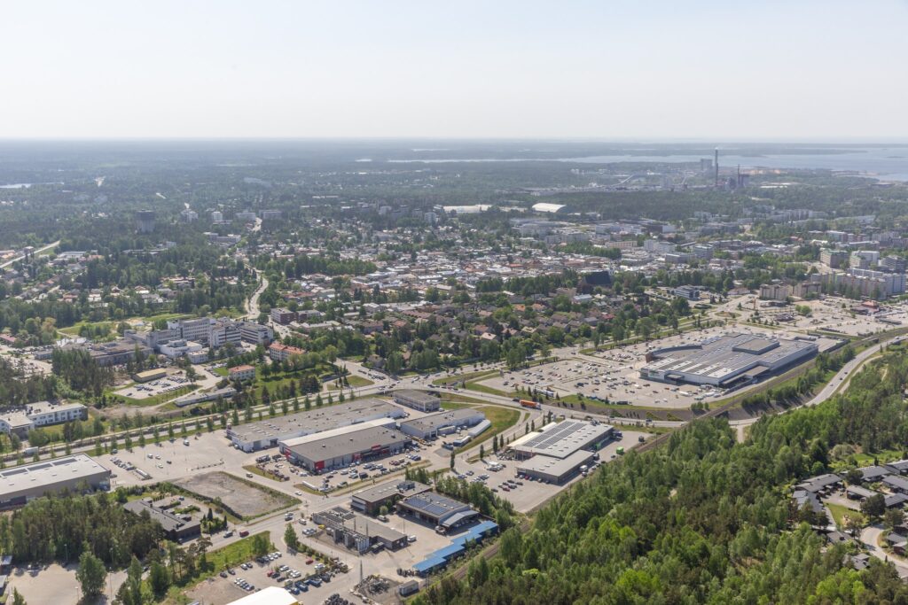 Aerial view of Rauma showing a retail area with shopping centers, parking lots and residential neighborhoods.